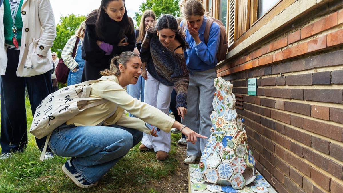 Centenary Ceramics: 100 People Pots and Peace Doves. People viewing a ceramic pot.