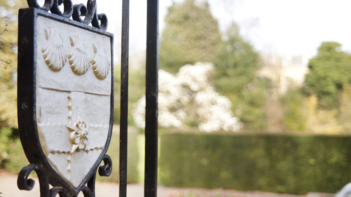 University of Reading crest in gold on a black gate