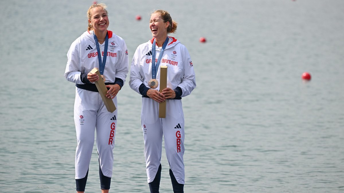 Photo of Mathilda and fellow rower wearing Olympic medals standing in front of a river at Paris 2024.