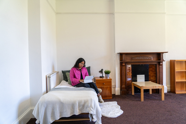 Student sat on bed with tablet device