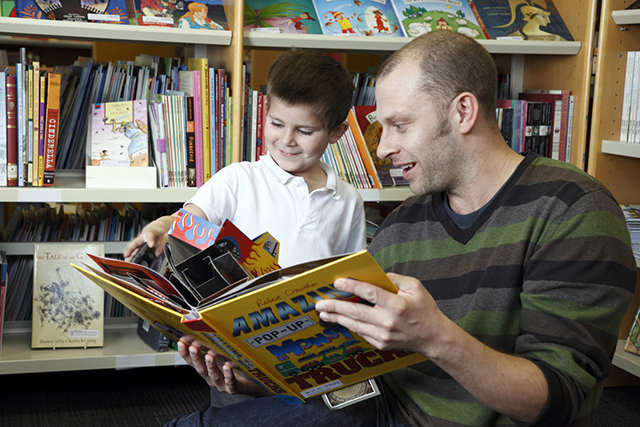 A man and child reading together